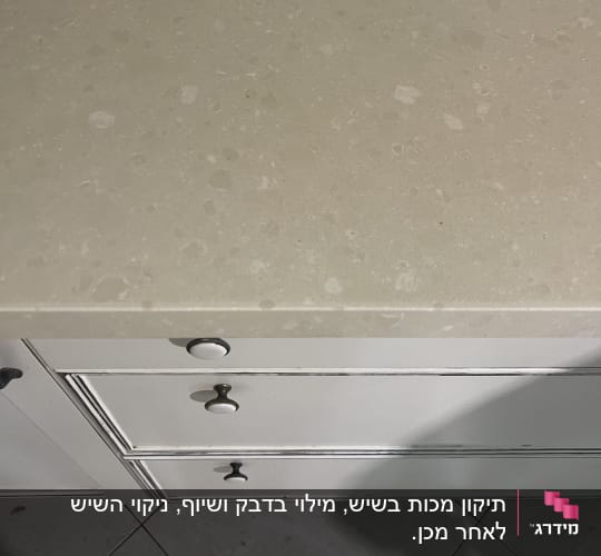 משטח שיש עם ארונות ומגירות